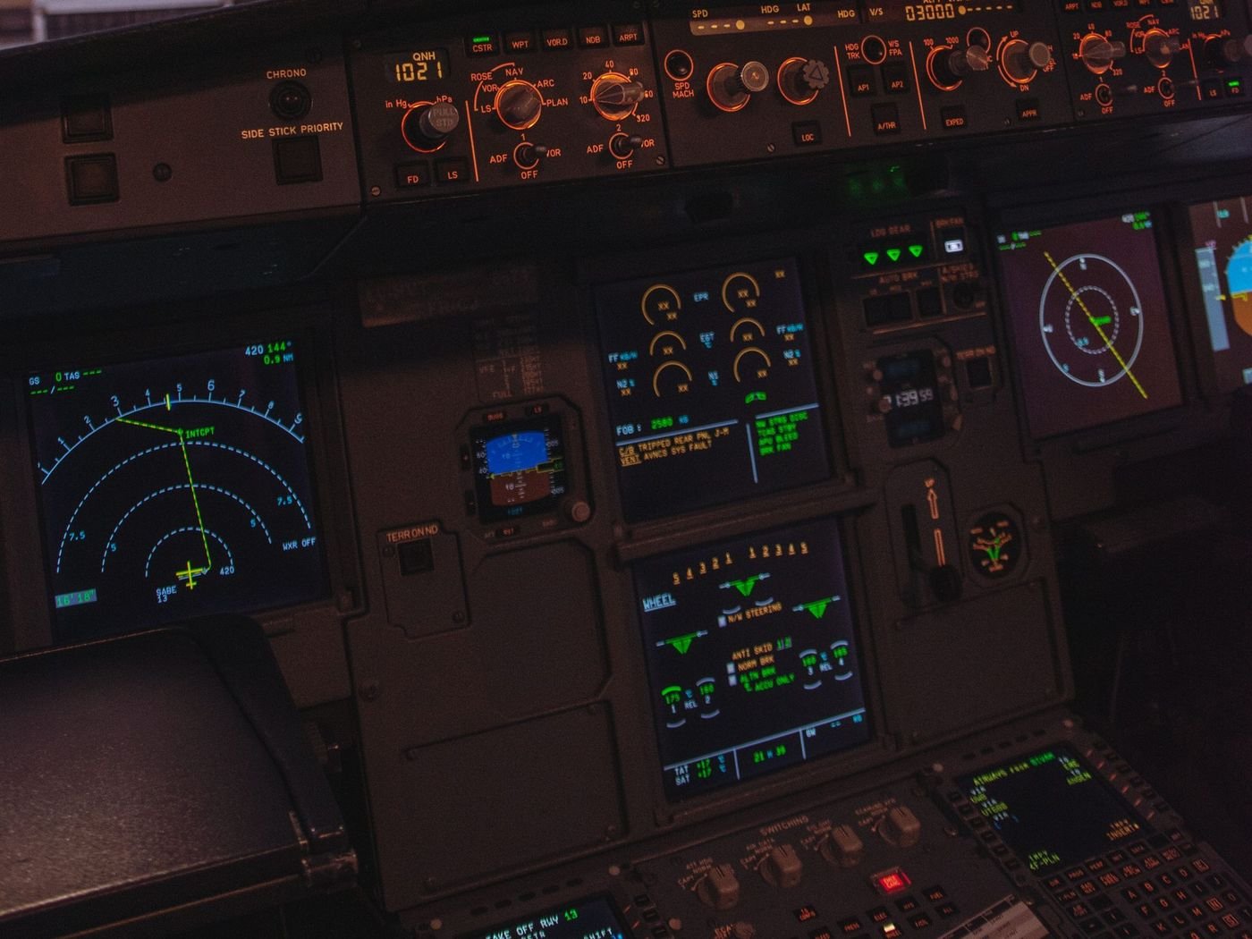 Cabina de un avión comercial de noche, con los instrumentos de vuelo encendidos.