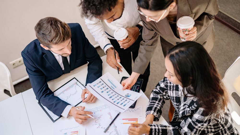 Equipo analizando información y tomando decisiones alrededor de una mesa